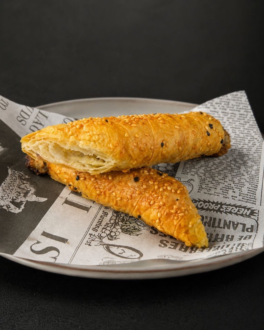 Sesame-crusted filo rolls torn open to show flaky layers, on our Instagram